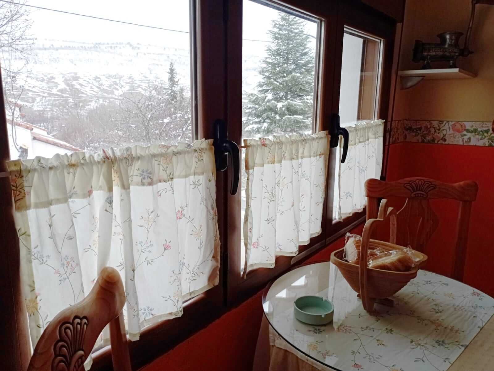 Una habitación con una mesa y sillas y una ventana.