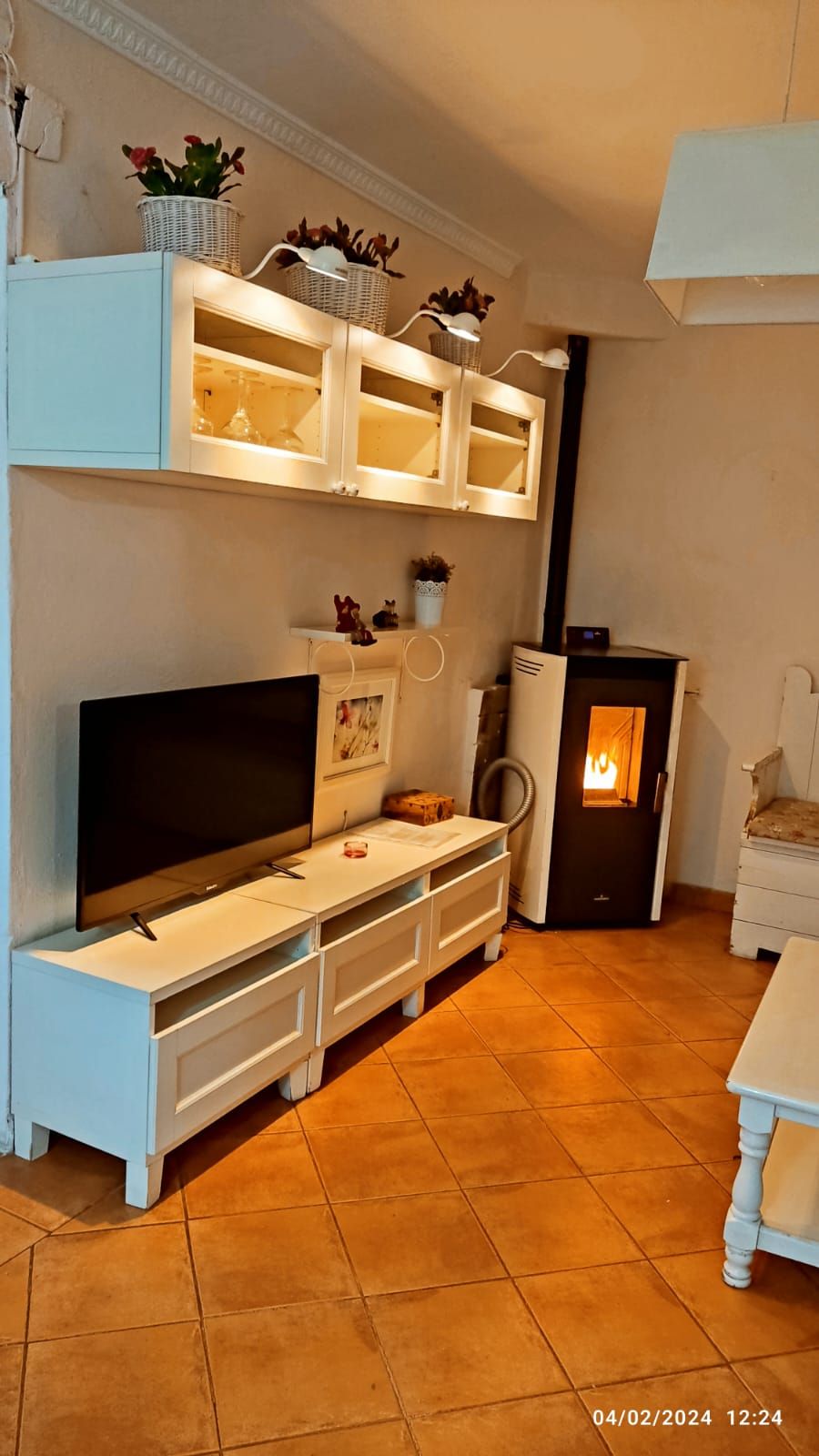 Una sala de estar con TV de pantalla plana y estufa.