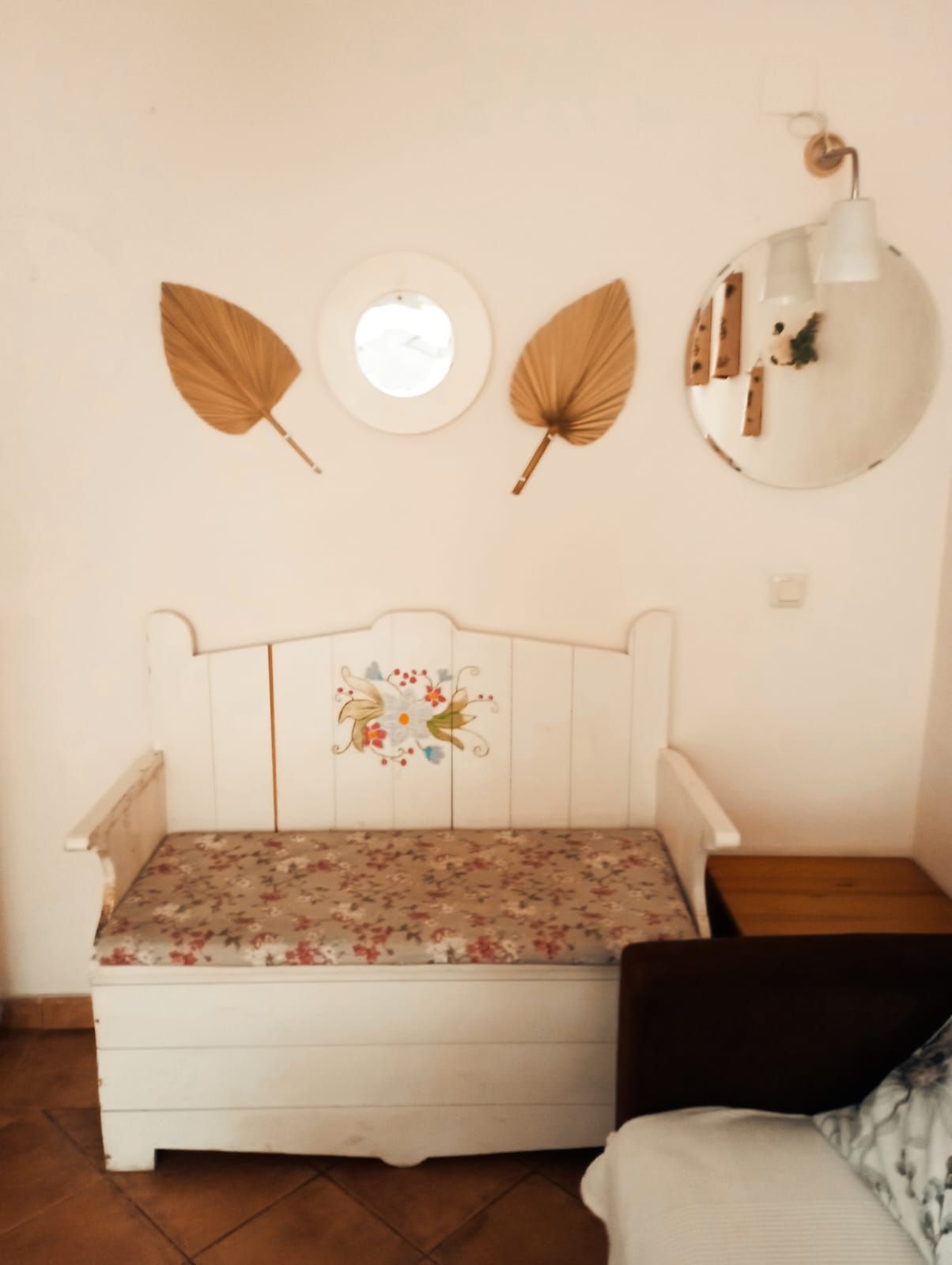 Un banco blanco en una habitación con un espejo en la pared.