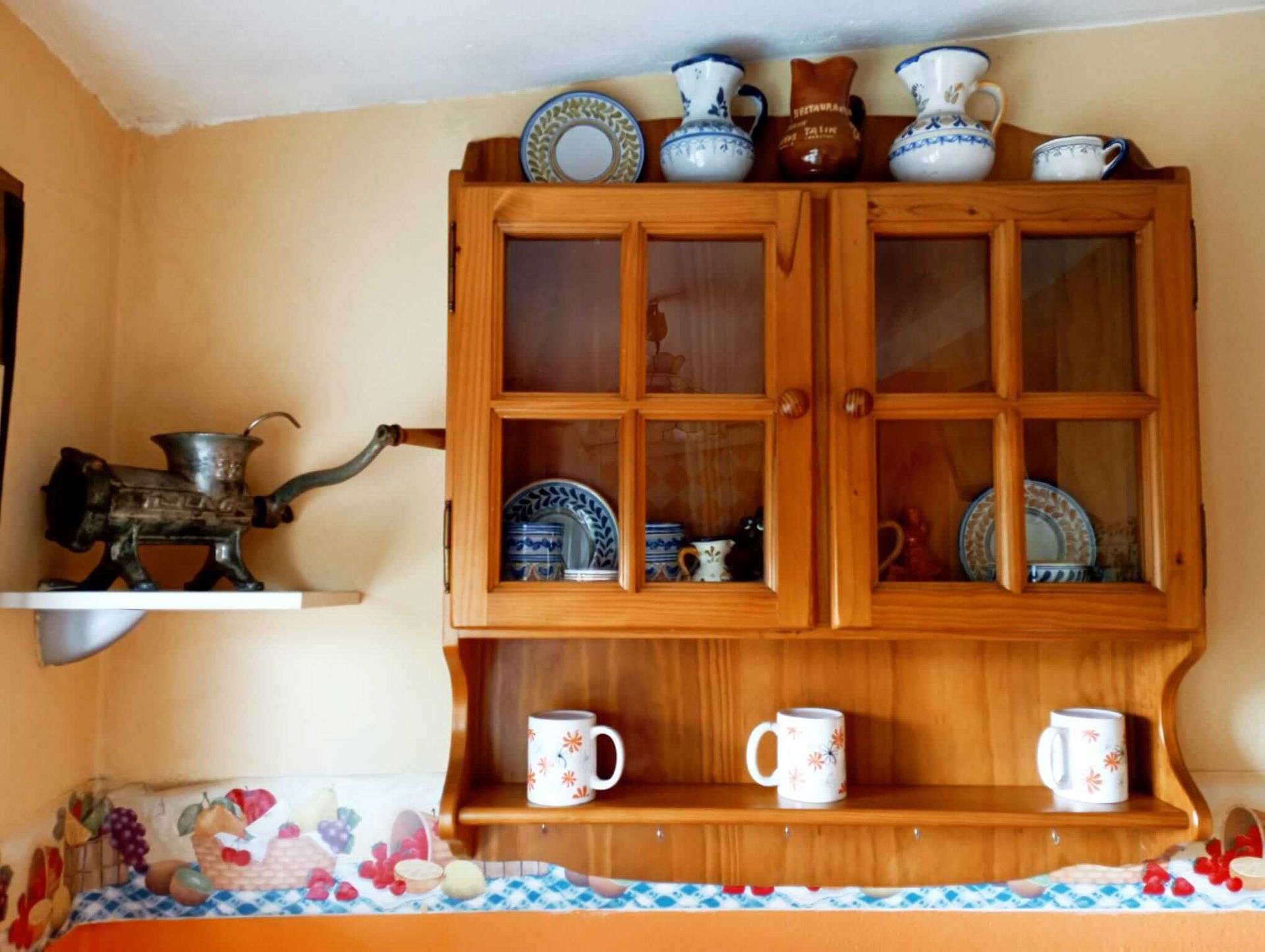 Un armario de madera con platos y tazas encima.