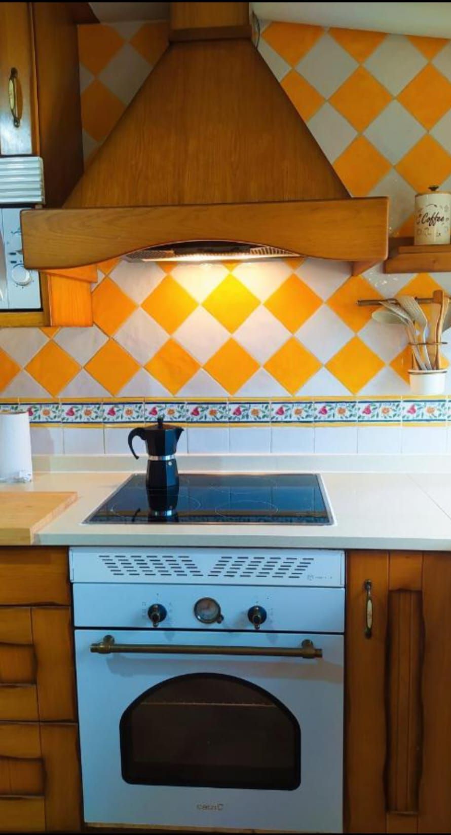 Una cocina con horno de estufa blanco y gabinetes de madera.