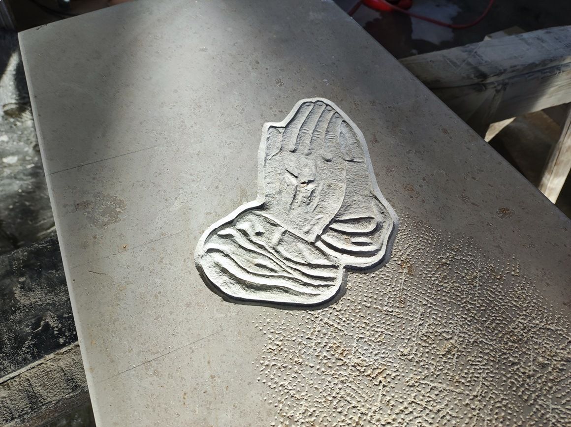 Symbol von betenden Händen ist auf einem Grabstein eingearbeitet