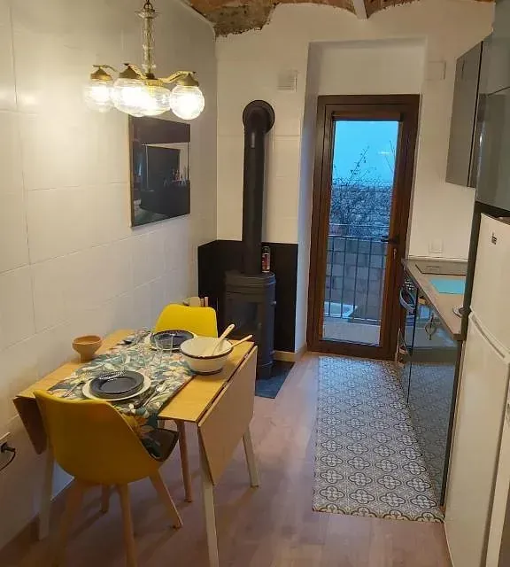 Una cocina con mesa y sillas y un refrigerador.