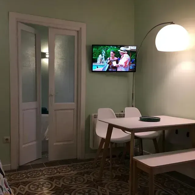 Una sala de estar con una mesa y sillas y un televisor de pantalla plana.