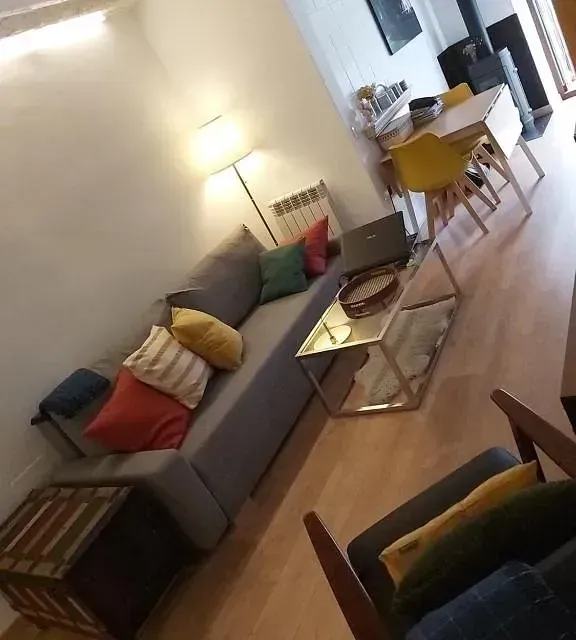 Una sala de estar con un sofá, una mesa y sillas.