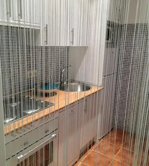 Una cocina con fregadero, estufa, refrigerador y gabinetes.