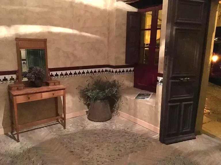 Una habitación con una mesa, un espejo y una planta en maceta.