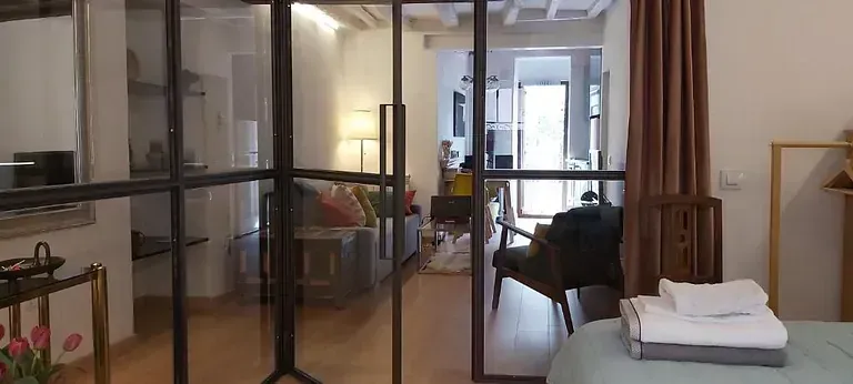 Un dormitorio con una puerta corrediza de vidrio que conduce a una sala de estar.