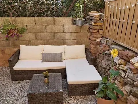 Hay un sofá y una mesa en el patio trasero.