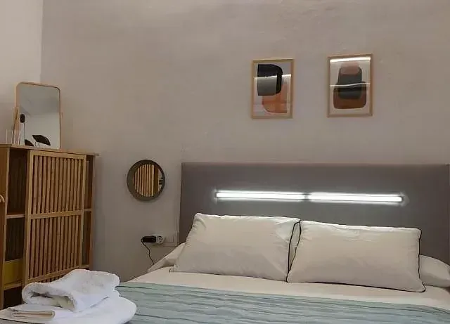 Un dormitorio con una cama y un espejo en la pared.