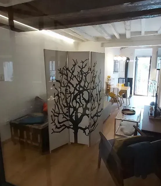 Una sala de estar con un divisor con un árbol encima.