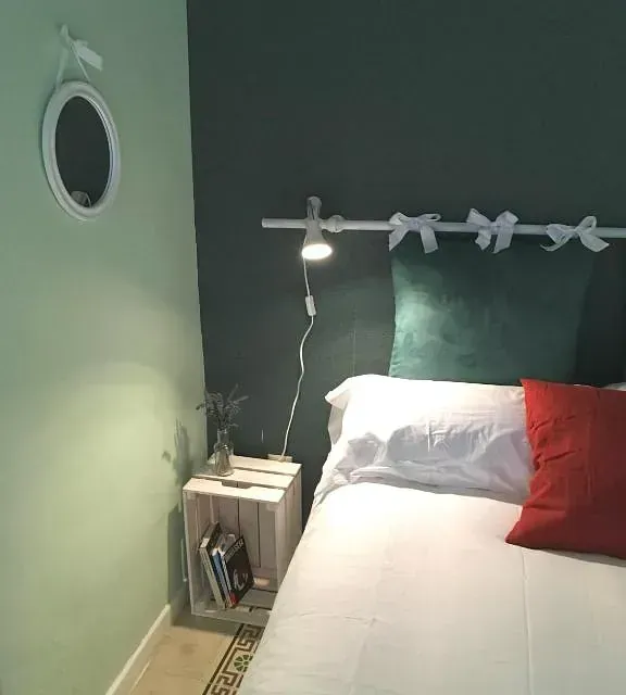 Un dormitorio con una cama y un espejo en la pared.