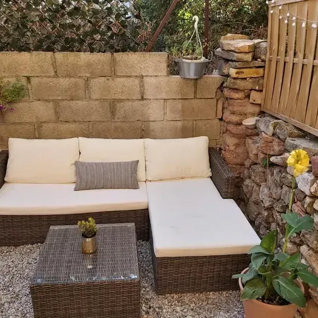 Un área de patio con un sofá y una mesa.