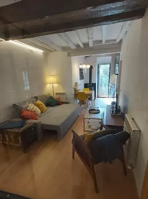 Una sala de estar con un sofá, sillas y una mesa.