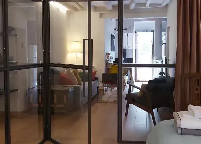 Una habitación con una puerta corrediza de vidrio que conduce a una sala de estar.