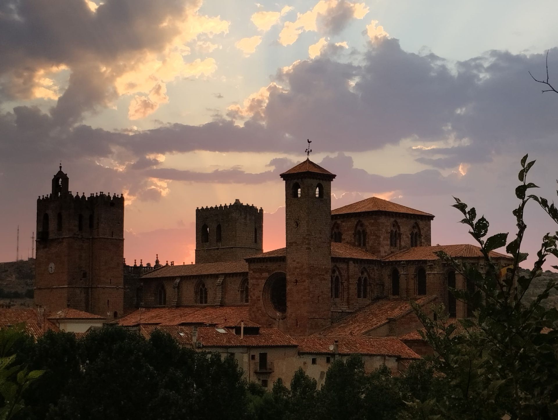 Un gran edificio con una puesta de sol al fondo.