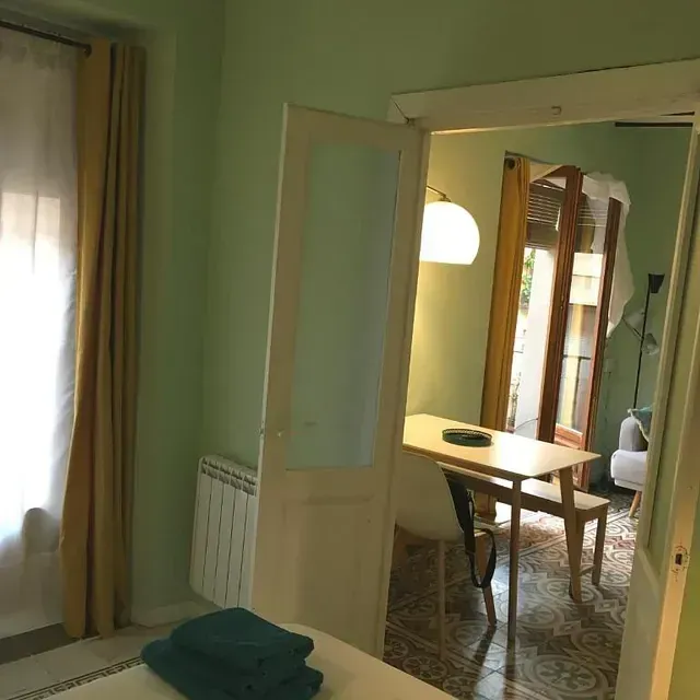 Un dormitorio con una mesa y sillas.