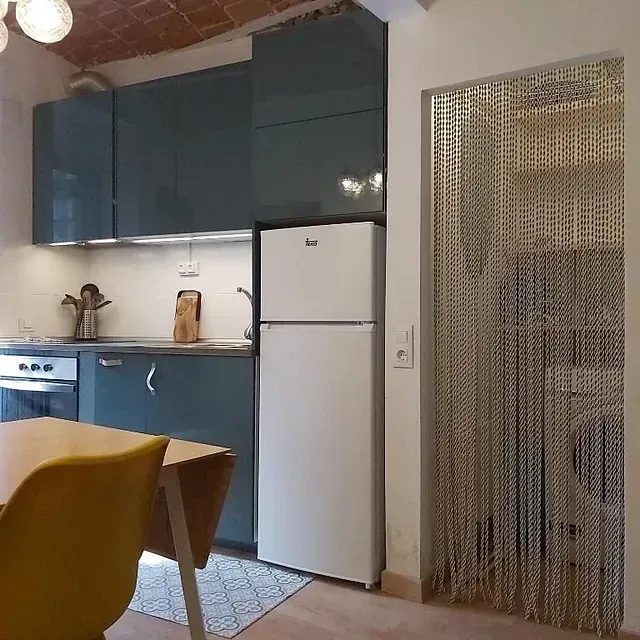 Una cocina con mesa y sillas y un refrigerador.