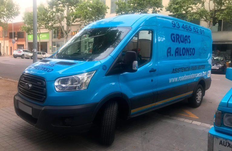 Una camioneta azul está estacionada al costado de la carretera.