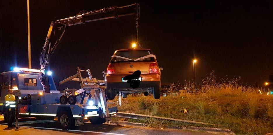 Un coche está siendo remolcado por una grúa por la noche.