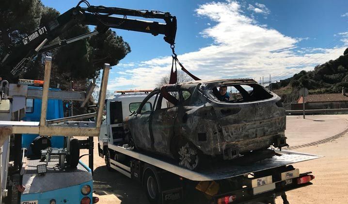 Un coche está siendo remolcado por una grúa con una grúa acoplada a él.