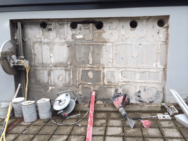 Offene Aussenwand mit einer Wasserwaage Kabelrolle und Spitzhammer