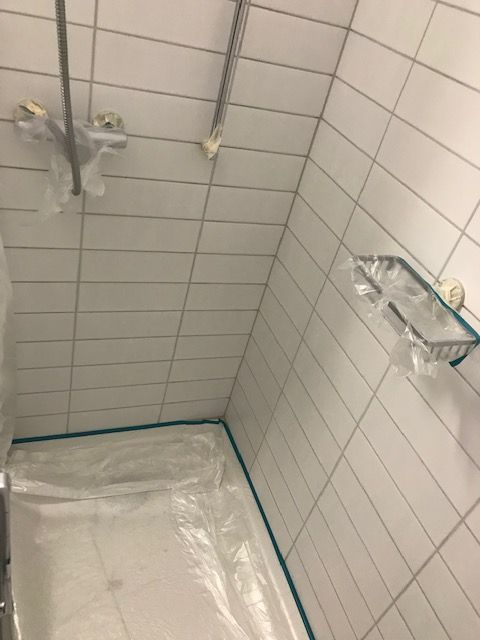 Aufgespitze Kacheln mit freigelegten Leitungen