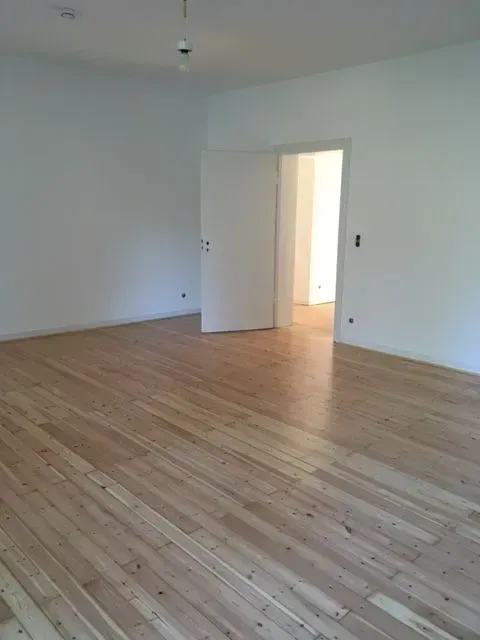 Weißer Raum mit hellbraunen Parkett