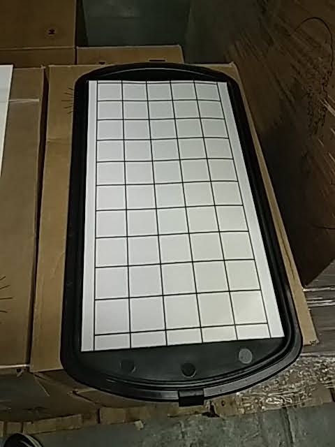 Un plateau noir et blanc avec des carrés dessus est posé sur une boîte.