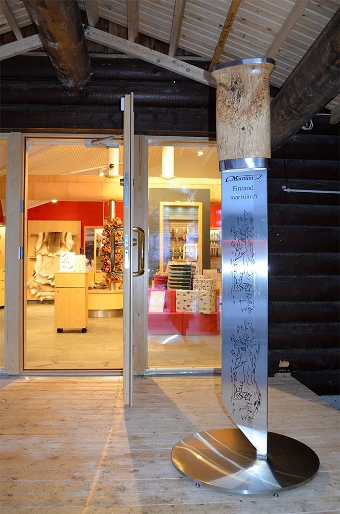 Moderni metalliveistos jalustalla gallerian sisäänkäynnillä, jossa on lämmin sisävalaistus