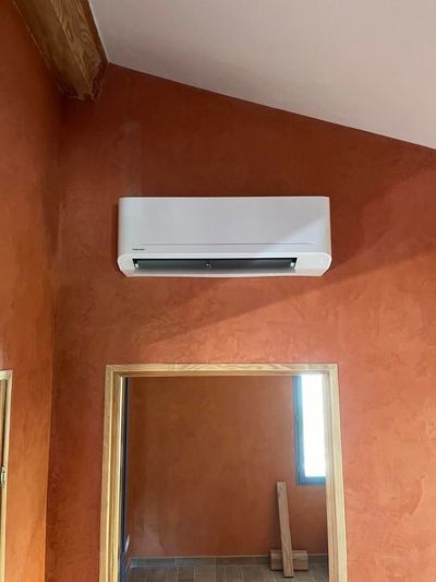 Climatiseur mural au-dessus d'une porte dans une pièce aux murs.