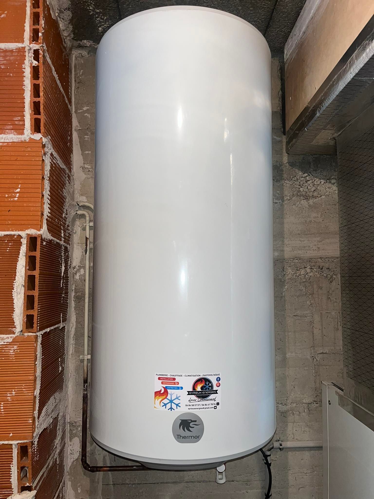 Chauffe-eau cylindrique, monté verticalement dans une niche utilitaire.