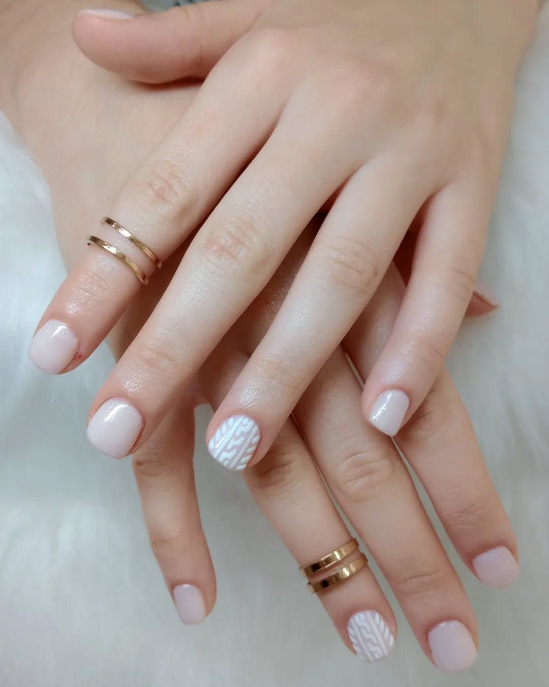 Un primer plano de las uñas de una mujer con anillos en ellas.