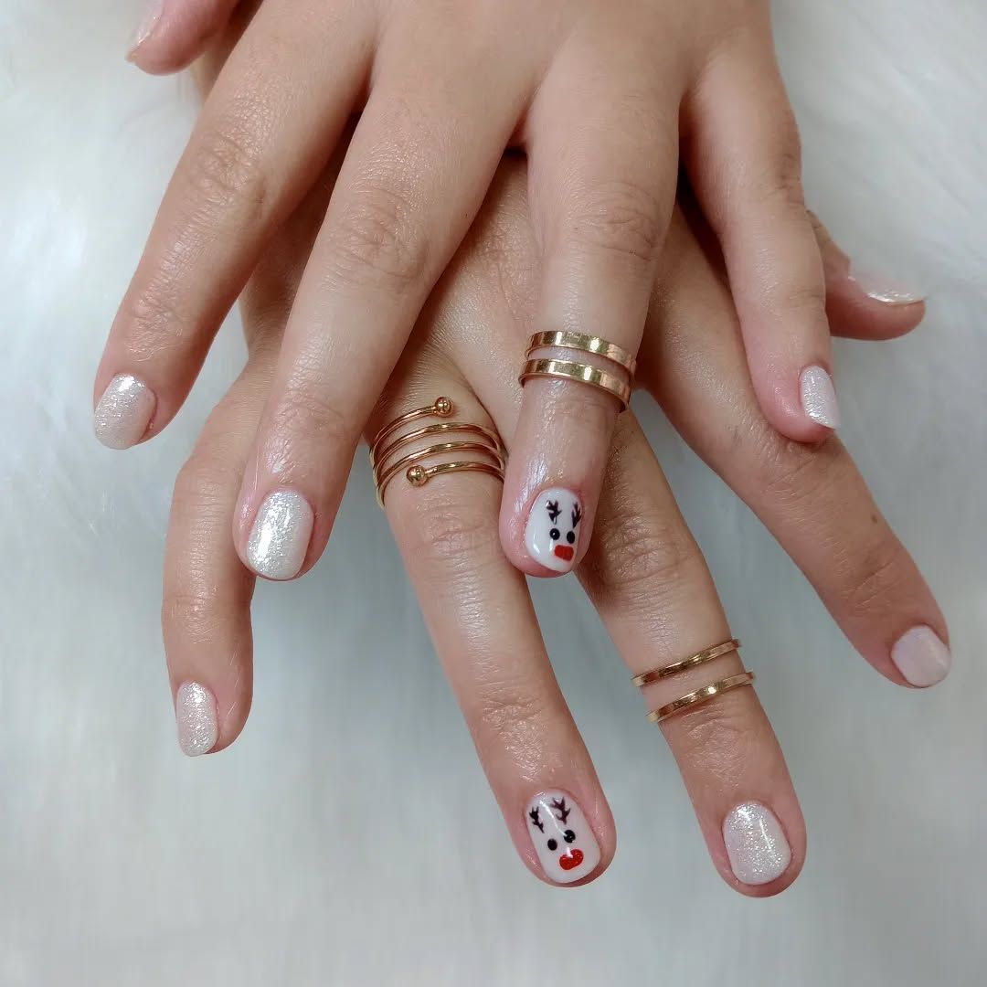 Un primer plano de las uñas de una mujer con anillos en ellas.