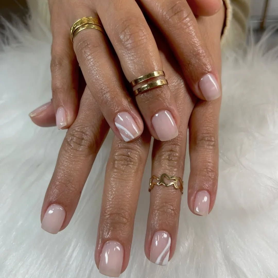 Un primer plano de las uñas de una mujer con anillos en ellas.