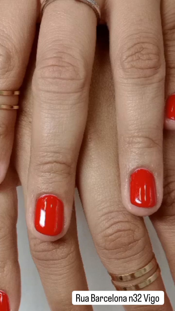 Un primer plano de las manos de una mujer con uñas rojas.