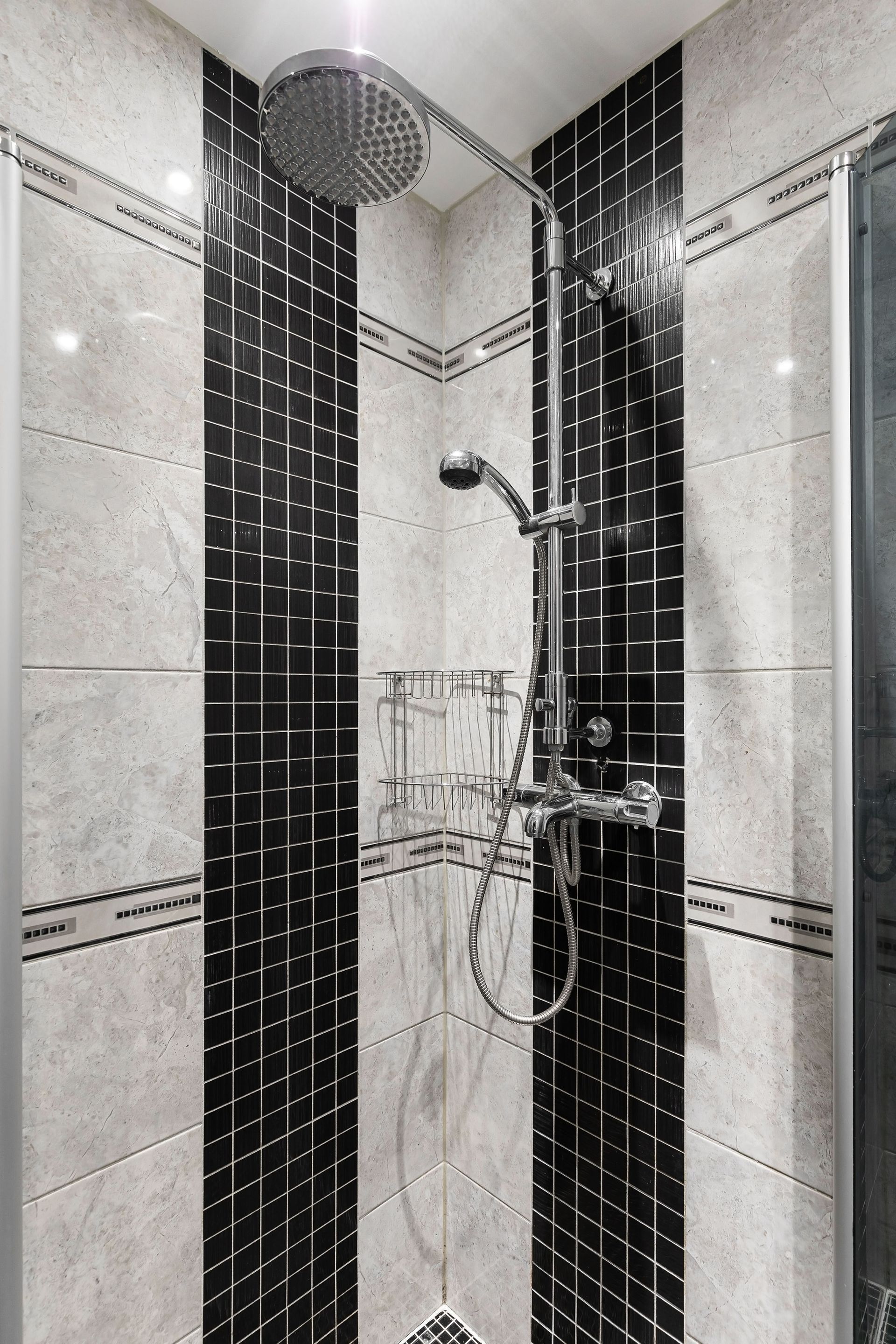 Douche moderne carrelée avec robinetterie chromée et pommeau de douche mural