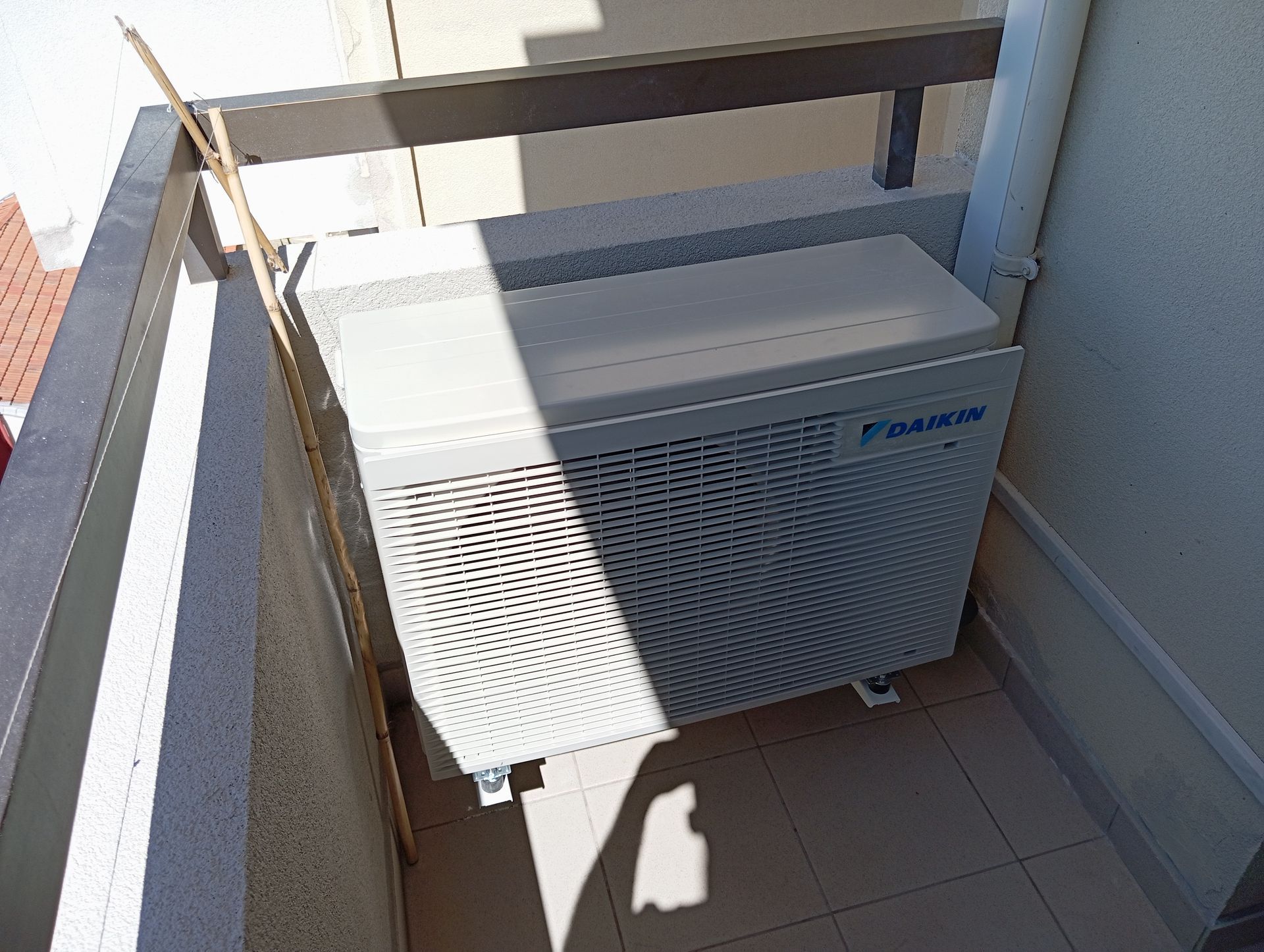 Unité de climatisation Daikin blanche sur un balcon.