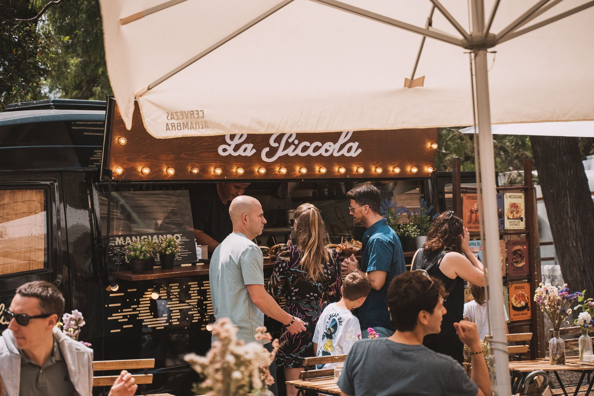 La gente se reúne cerca de un camión de comida, 
