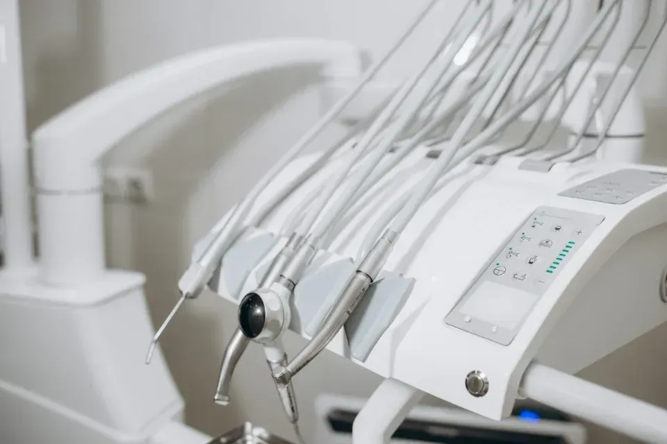 Instrumental de clínica dental y panel de control en un sillón de tratamiento blanco.