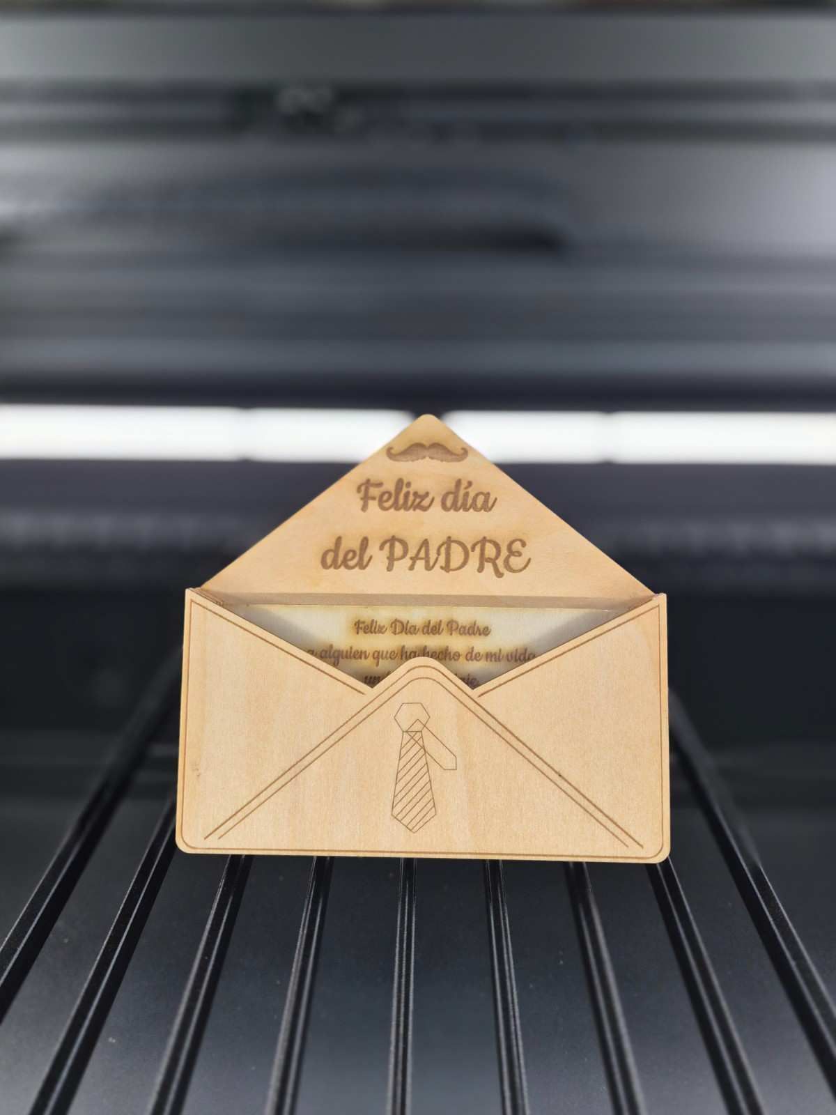 Tarjeta del Día del Padre en madera con diseño de sobre, texto en español.