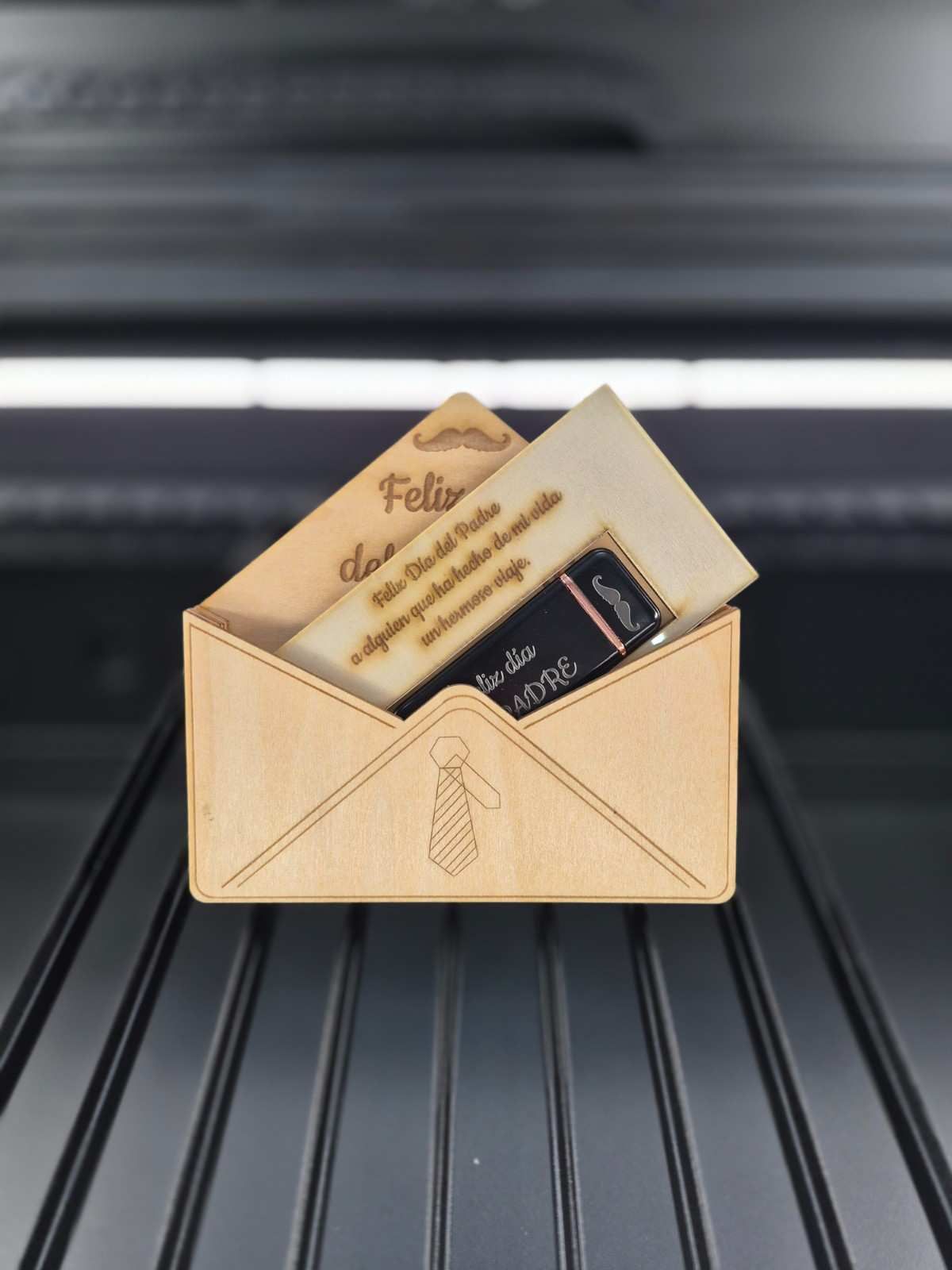 Sobre de madera cortado a láser con tarjetas. Una tarjeta tiene el texto 