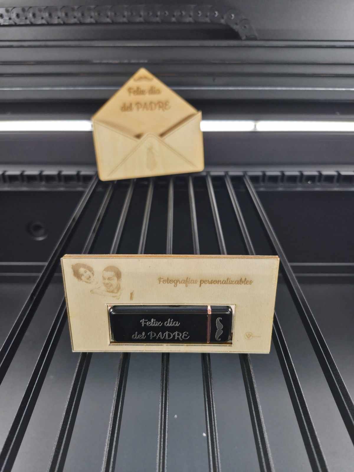 Tarjeta y sobre de madera para el Día del Padre sobre estantes negros.