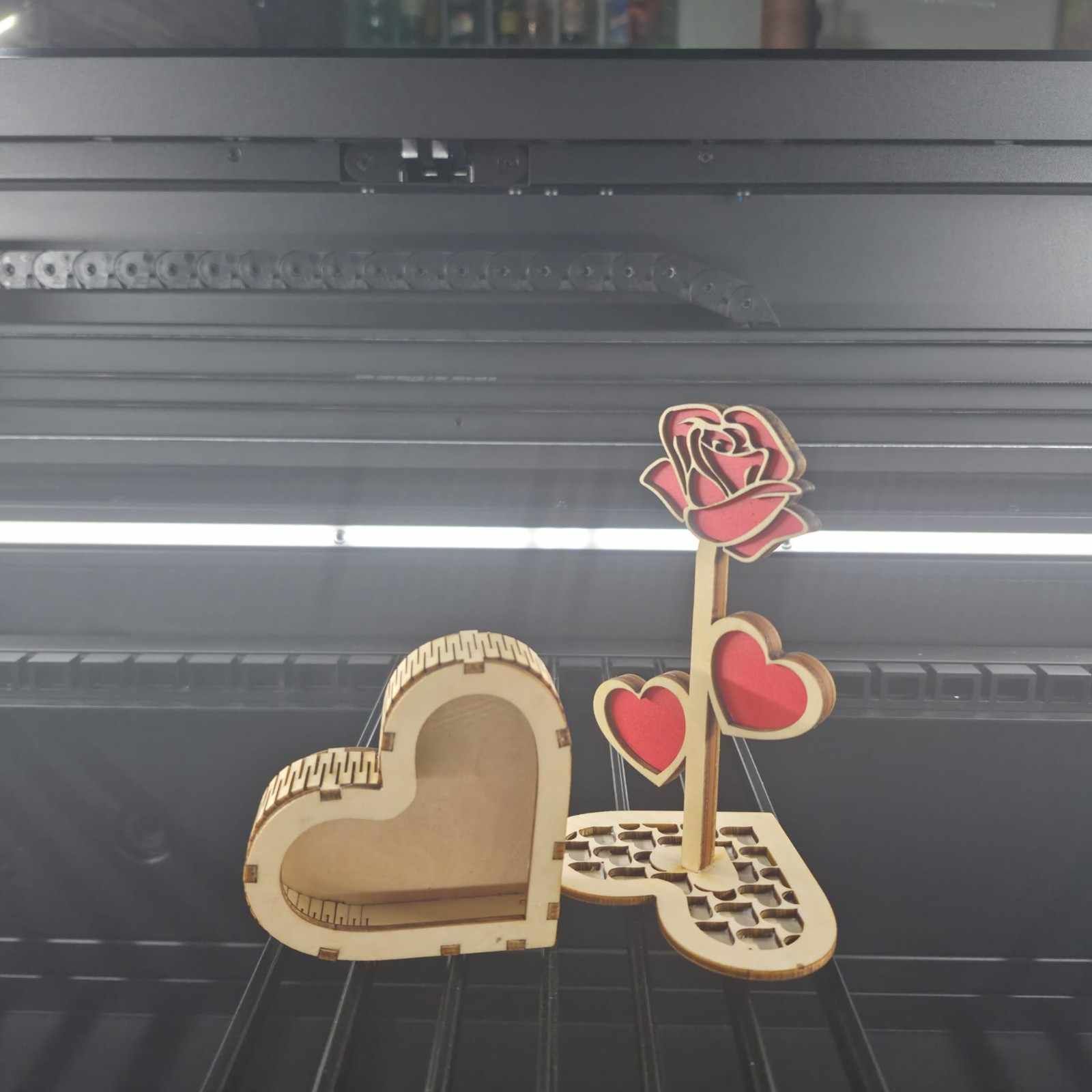 Caja de madera en forma de corazón y rosa con corazones. Madera clara con detalles en rojo.