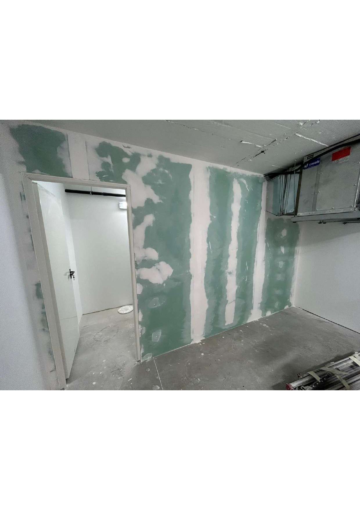 Una habitación con una puerta y una pared que está siendo remodelada.
