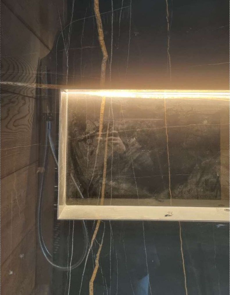 Un baño con un lavabo y un espejo con una luz detrás.