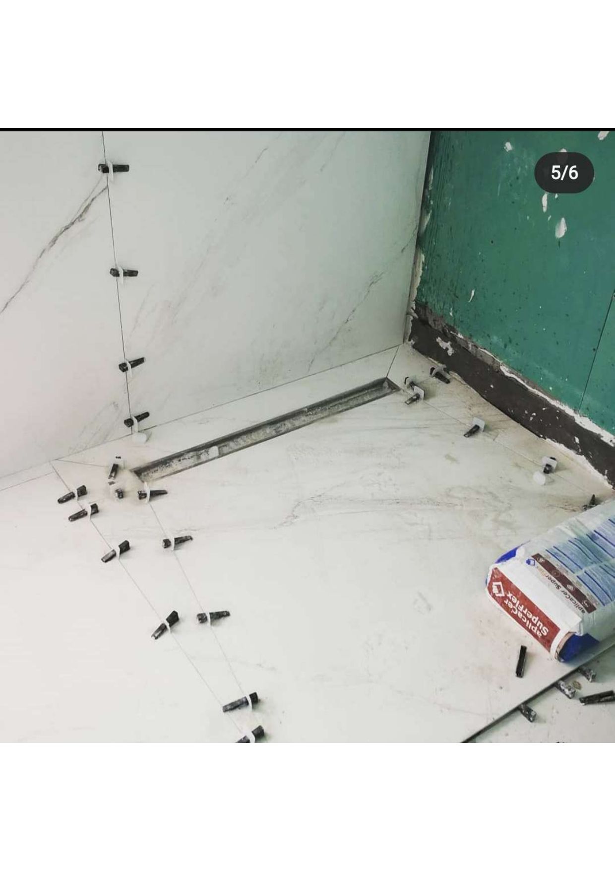 Una imagen de un piso de baño siendo alicatado.