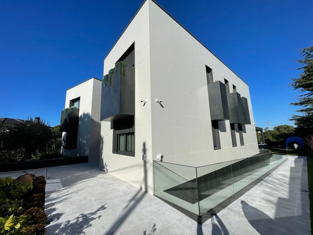 Un gran edificio blanco con una barandilla de vidrio en el costado.