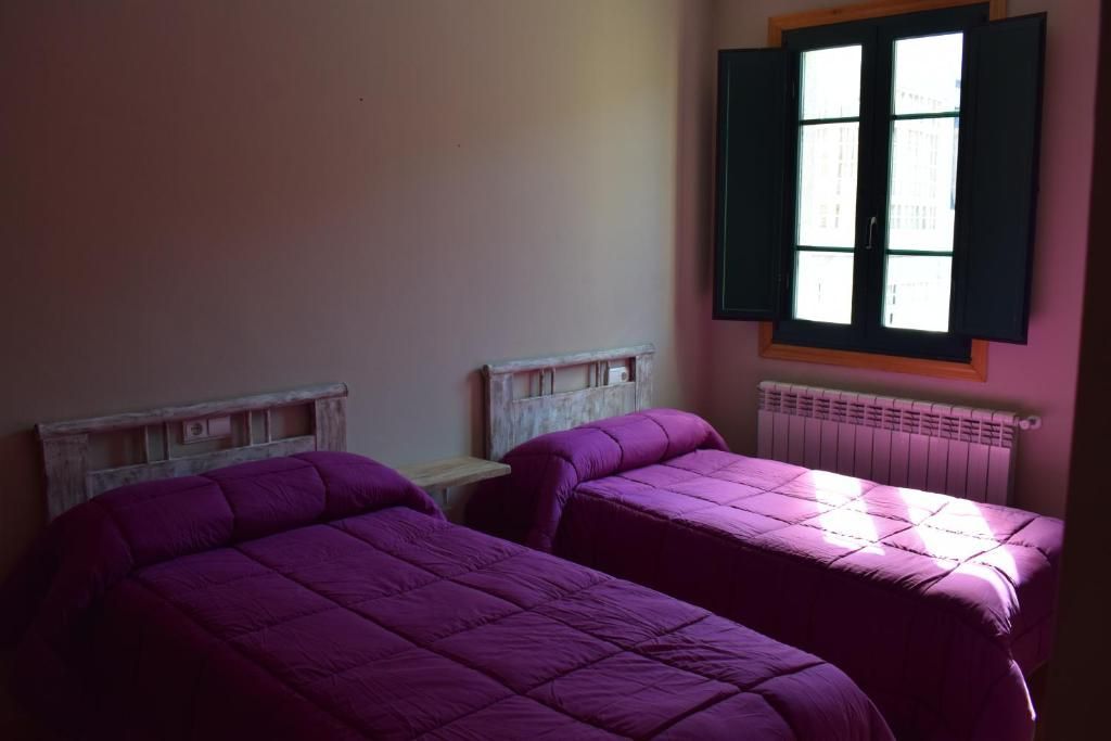Un dormitorio con una cama individual, una ventana y un cuadro en la pared.