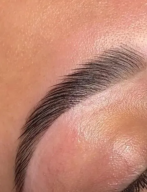 Un primer plano de las cejas de una mujer con maquillaje.